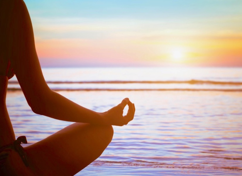 A person meditating on the beach